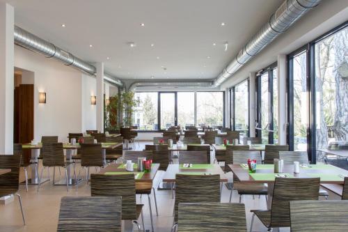 维也纳斯宾格斯科尔赛米娜酒店的用餐室设有桌椅和窗户。