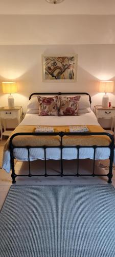 East BudleighDelightful Devon Cottage的卧室内的一张床位,配有2个床头柜和2盏灯