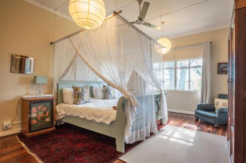 阿马卡拉保护区Tygerfontein Safari Villa的一间卧室配有天蓬床和蓝椅
