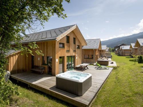 穆劳附近圣洛伦岑Wooden Chalet in Sankt Georgen ob Murau with Sauna的木甲板上带热水浴池的房子