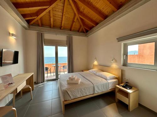 莫奈姆瓦夏Pasithea Suites的一间卧室配有一张床,享有海景