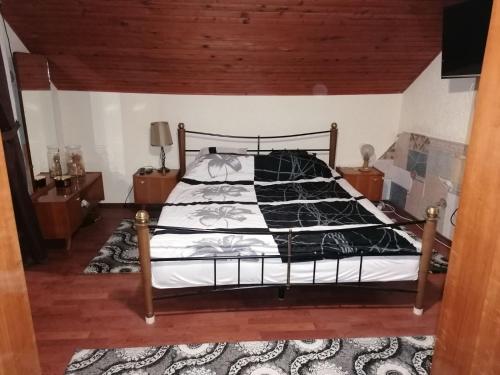 BatinaKuća za odmor Dunavski raj的一间卧室配有一张带黑白色棉被的床