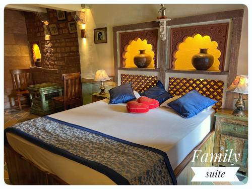 焦特布尔Raj Mandir Boutique Home Stay的一间卧室配有一张带蓝色和红色枕头的大床