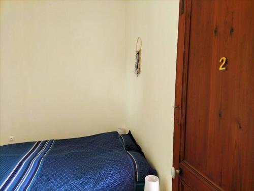 圣迈克桑莱科勒Logement entier pour 6 personnes的一间小卧室,配有一张床和一扇木门