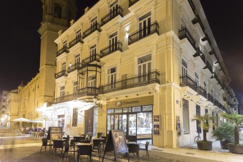 瓦伦西亚圣洛伦索精品酒店的前面设有桌椅的黄色建筑