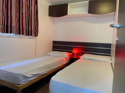 索托马里纳Villaggio Camping Europa的红色灯小客房内的两张床
