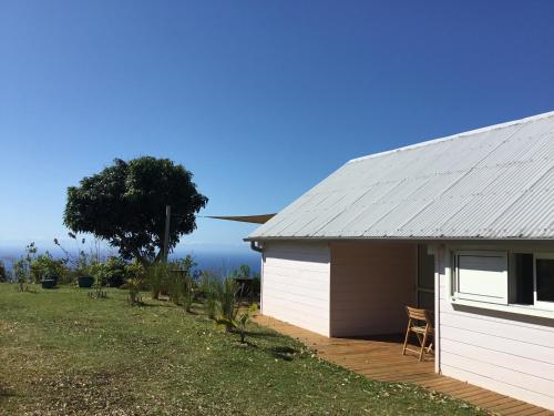 圣丹尼斯Gîte rural _ vue Océan _ des bateaux dans le ciel的旁边设有一张桌子和椅子的白色棚子