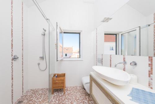 赫瓦尔马吉独家公寓的白色的浴室设有水槽和淋浴。