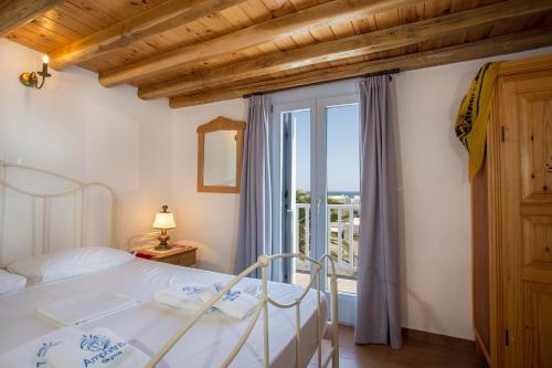 斯基罗斯岛Amphitrite Apartments Skyros的一间卧室设有一张床和一个大窗户