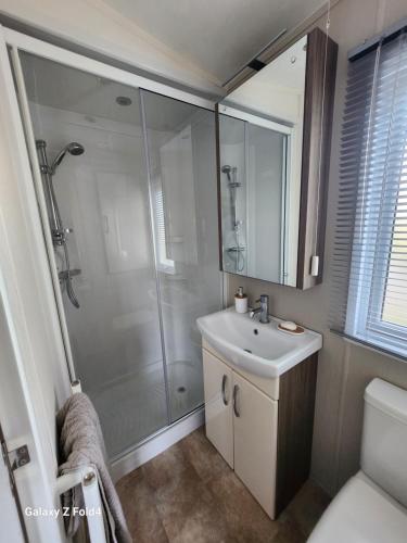 滨海莱斯当Seaview的带淋浴和白色盥洗盆的浴室