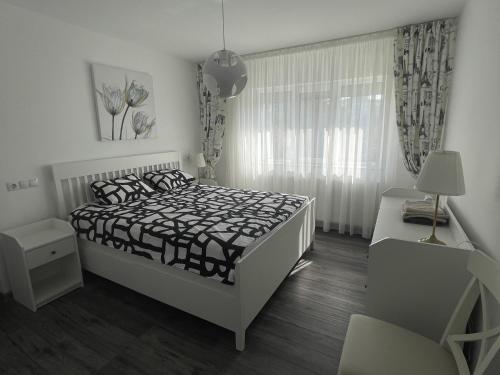 BuzăuVulcan Apartment的白色的卧室设有床和窗户