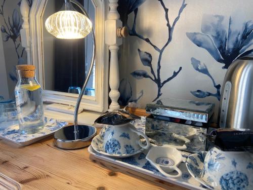 韦姆Abbey Green Farm的一张带蓝色和白色花瓶及镜子的桌子
