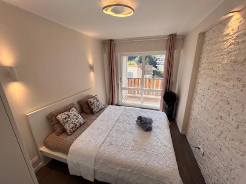 戛纳Les Arènes - Cannes centre, Charmant 2 pièces récemment rénové de 45 m2 avec sa terrasse de 10 m2的一间卧室设有一张床和一个窗口