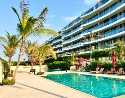 卡塔赫纳Espectacular Aparta Estudio Loft en Playa Manzanillo Cartagena的一座棕榈树度假村游泳池和一座建筑