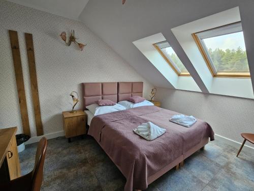BondaryDolcevita Podlasie的一间卧室配有粉红色的床和2条毛巾
