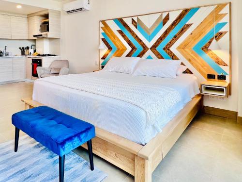 卡塔赫纳Espectacular Aparta Estudio Loft en Playa Manzanillo Cartagena的一间卧室设有一张大床和一张蓝色凳子