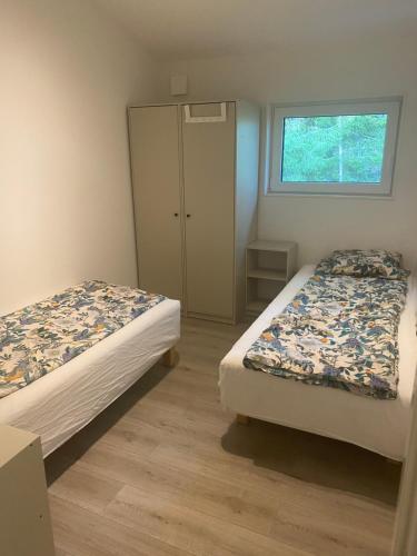 顺托普Sjölanda的一间卧室设有两张床、一个橱柜和一个窗口。