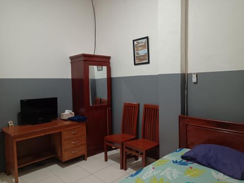 查亚普拉OYO 93117 Penginapan Tiga Dara的一间卧室配有一张床、一张桌子和一台电脑