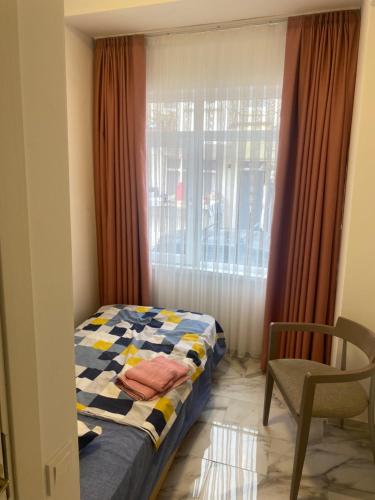 伊斯坦布尔yenikap hotel的一间卧室设有一张床、一个窗口和一把椅子