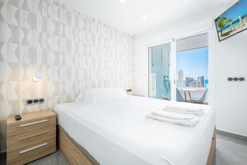 贝尼多姆Gemelos 22-3-21D Apartment Deluxe Levante Beach的白色的卧室设有一张大床和一个窗户