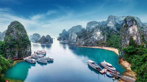 河内Halong Bay Full Day Cruise Kayaking, Swimming, Hiking:ALL INCLUDE的一群船停靠在一条有山脉的河流中