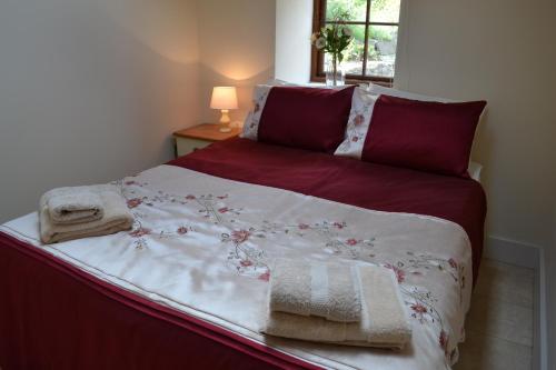 塞特尔Ashes Farm - Ingleborough View cottage的一张铺有红白色床单和毛巾的床