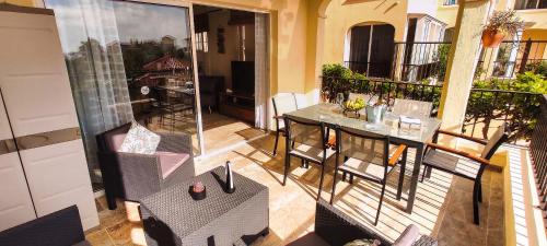 圣米格尔德阿沃纳Casa Palmu apartment - A peaceful and relaxing oasis in Golf del Sur, Tenerife的阳台配有桌椅。