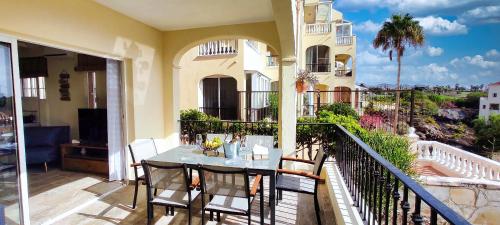 圣米格尔德阿沃纳Casa Palmu apartment - A peaceful and relaxing oasis in Golf del Sur, Tenerife的阳台的天井配有桌椅