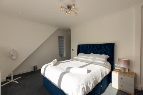 Six Mile BottomThe Mayfair的一间卧室配有一张大床和蓝色床头板