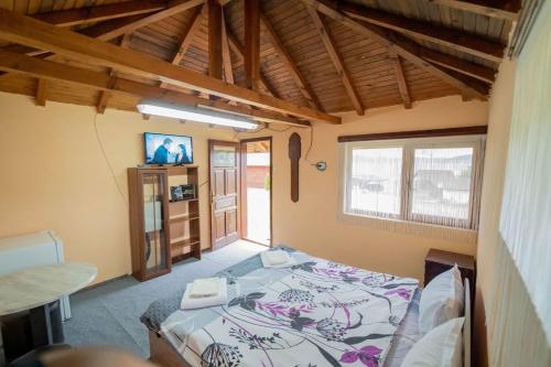 巴塔克Madjestic Houses的一间卧室配有一张床和一台电视。