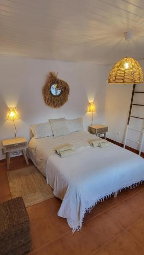 米尔芳提斯城Cantinho de Milfontes Jacuzzi的一间卧室配有一张大床和两盏灯。