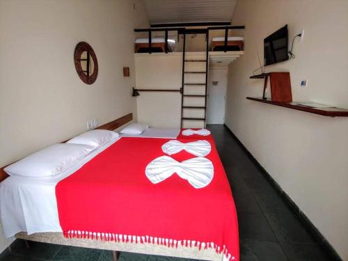 塞古罗港POUSADA DAS FLORES的一间卧室配有一张带红色毯子的床