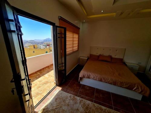 瓦迪穆萨Petra Sunset Bed & Breakfast的一间卧室设有一张床和一个滑动玻璃门