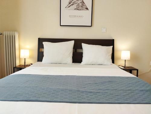 雅典生活超便利的小公寓的一张大床,配有两个枕头和两盏灯