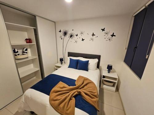 埃雷迪亚Charming Retreat Heredia: Your Home Away from Home的卧室配有一张带蓝色枕头的床,墙上有鸟儿