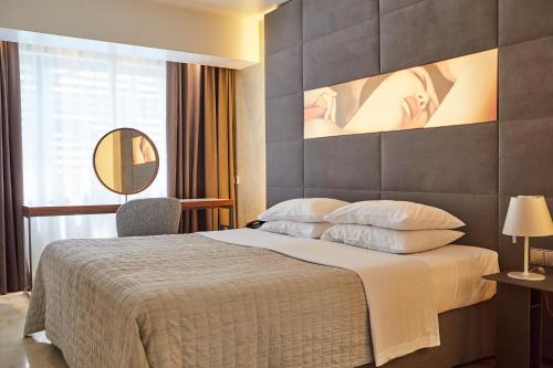 雅典巴西套房精品酒店 的配有一张大床和镜子的酒店客房