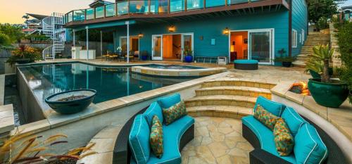 圣地亚哥Breathtaking La Playa Getaway With Golf Cart Use!的一座带蓝色椅子的游泳池的房子