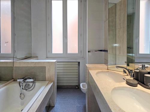 图卢兹L'Idrac, Appartements en Hyper centre的浴室配有两个盥洗盆和浴缸。
