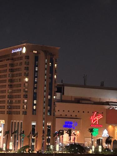 开罗Ramo City Stars Hotel的一座大建筑,晚上有标志