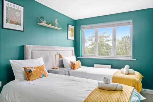 WoolstoneBeautiful 2 Bedroom Apartment MK Free Parking的蓝色墙壁客房的两张床