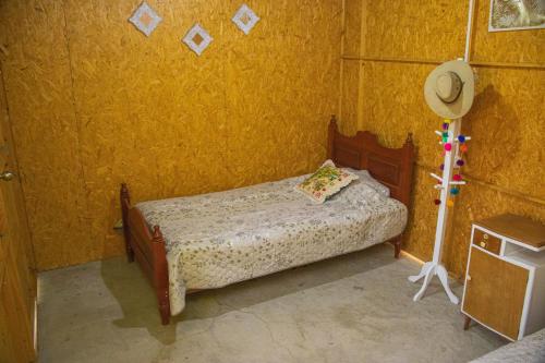 卢那欢纳Qintipillpi Lunahuaná的一间小卧室,卧室的黄色墙壁上配有一张床铺