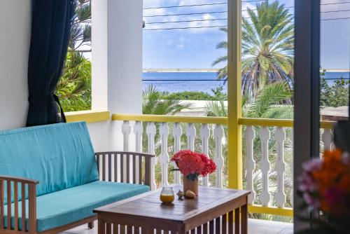 克拉伦代克Diver's Paradise Bonaire的阳台配有桌椅,享有海景。