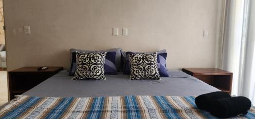 图卢姆Kin Tulum House downtown的一间卧室配有一张带蓝色枕头的床