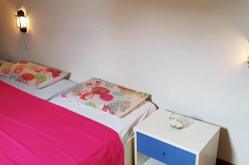 洛夫兰Apartment Dhalia的客房设有2张带粉色床单和时钟的床。