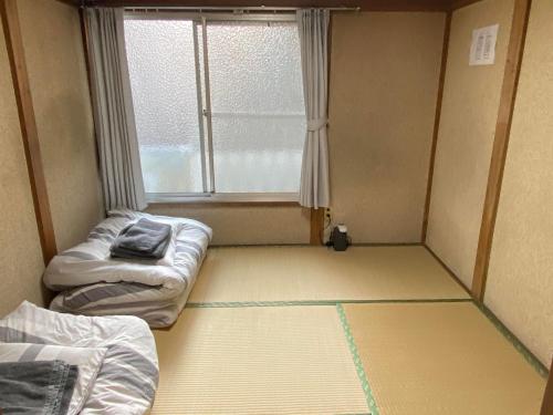 东京Little Bird Takinogawa #1的小房间设有两张床和窗户