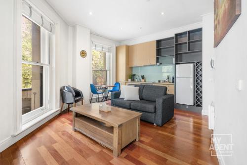 墨尔本Melbourne Bourke Street Bliss的客厅配有沙发和桌子