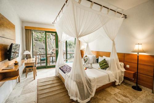 乌布Sabana Ubud的一间卧室配有一张天蓬床和一张书桌