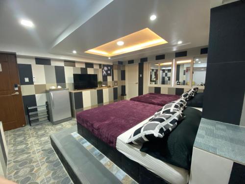 波尔多·格尼拉Anak Jay Ang的一间卧室配有一张床和一台电视。