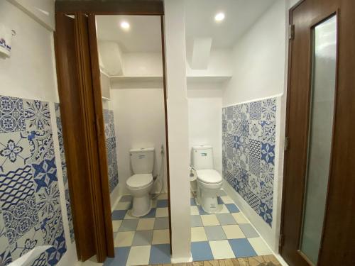 波尔多·格尼拉Anak Jay Ang的浴室设有2个卫生间,铺有蓝色和白色瓷砖。