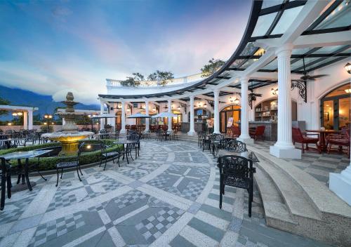萨帕Silk Path Grand Sapa Resort & Spa的一座带喷泉和桌椅的建筑